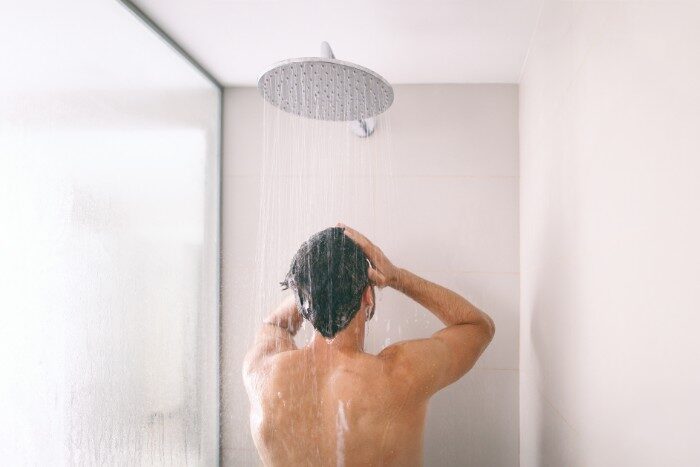 Man enjoying a refreshing shower with soft water for healthier skin