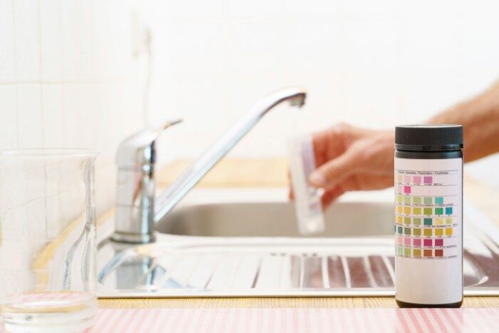 Hard water test strips showing different water hardness levels