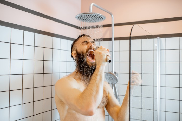 Man enjoying a shower with softened water after fixing water softener problems