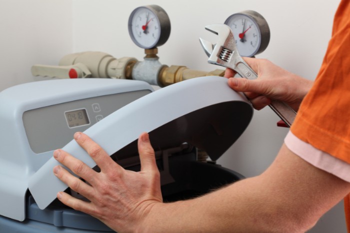 Professional technician repairing a water softener system