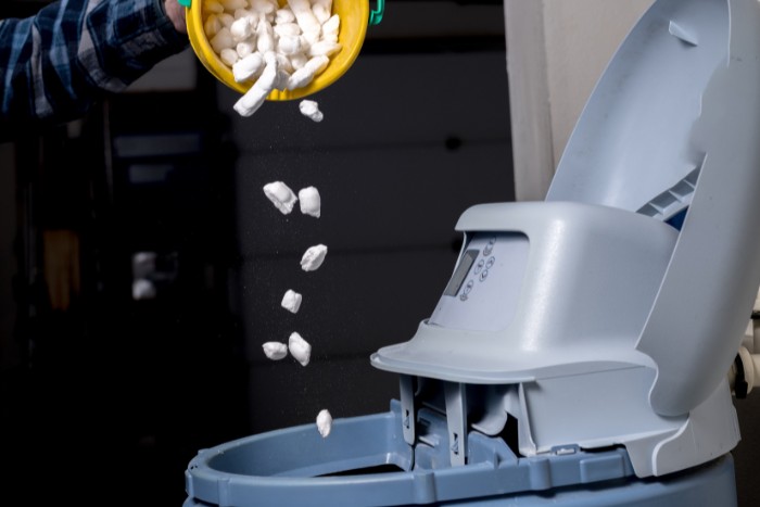 Refilling the brine tank with salt to prevent water softener problems
