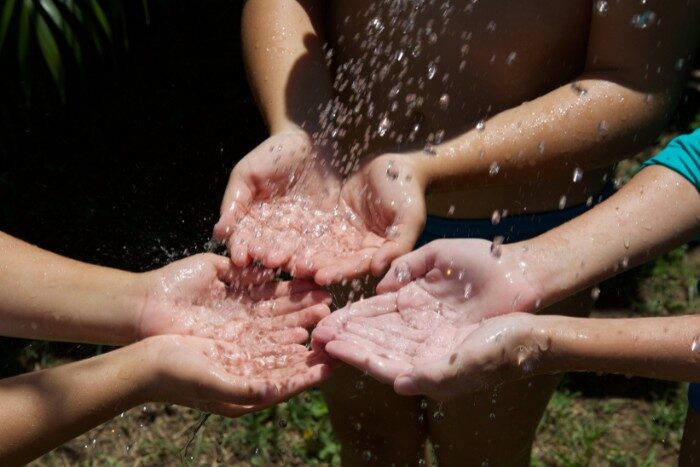 Clean softened water flowing into hands after using a salt-based water softener in Phoenix