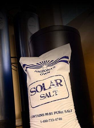 Pouring fresh salt into the water softener system during routine maintenance