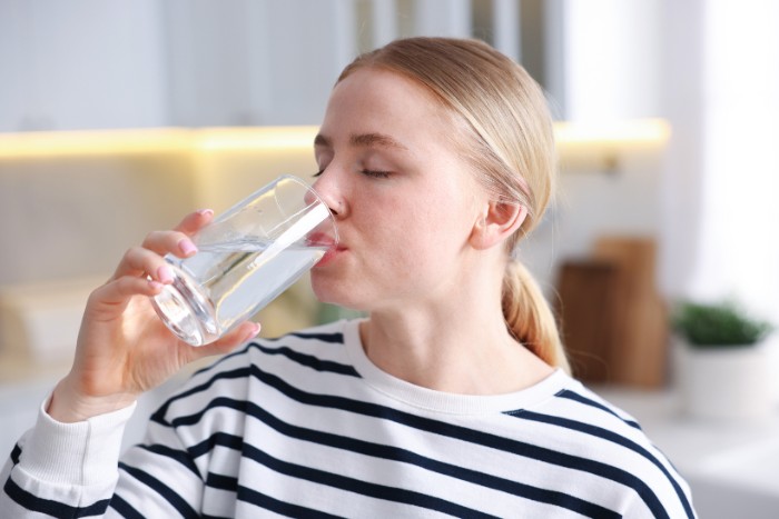 Woman drinking hard water in a Phoenix home
